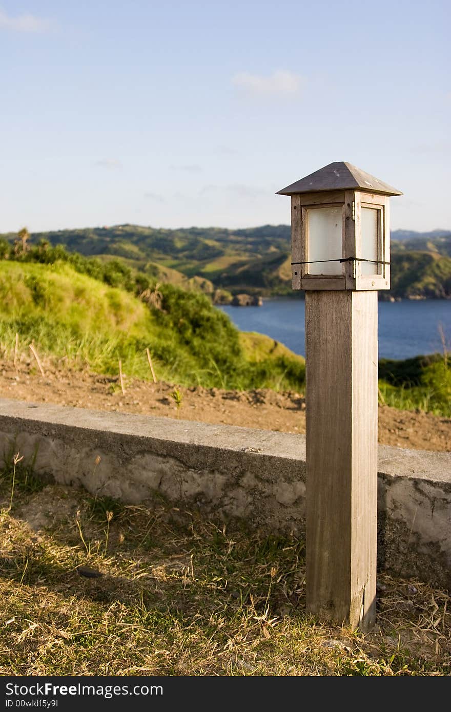 A wooden light post on a grassy patch