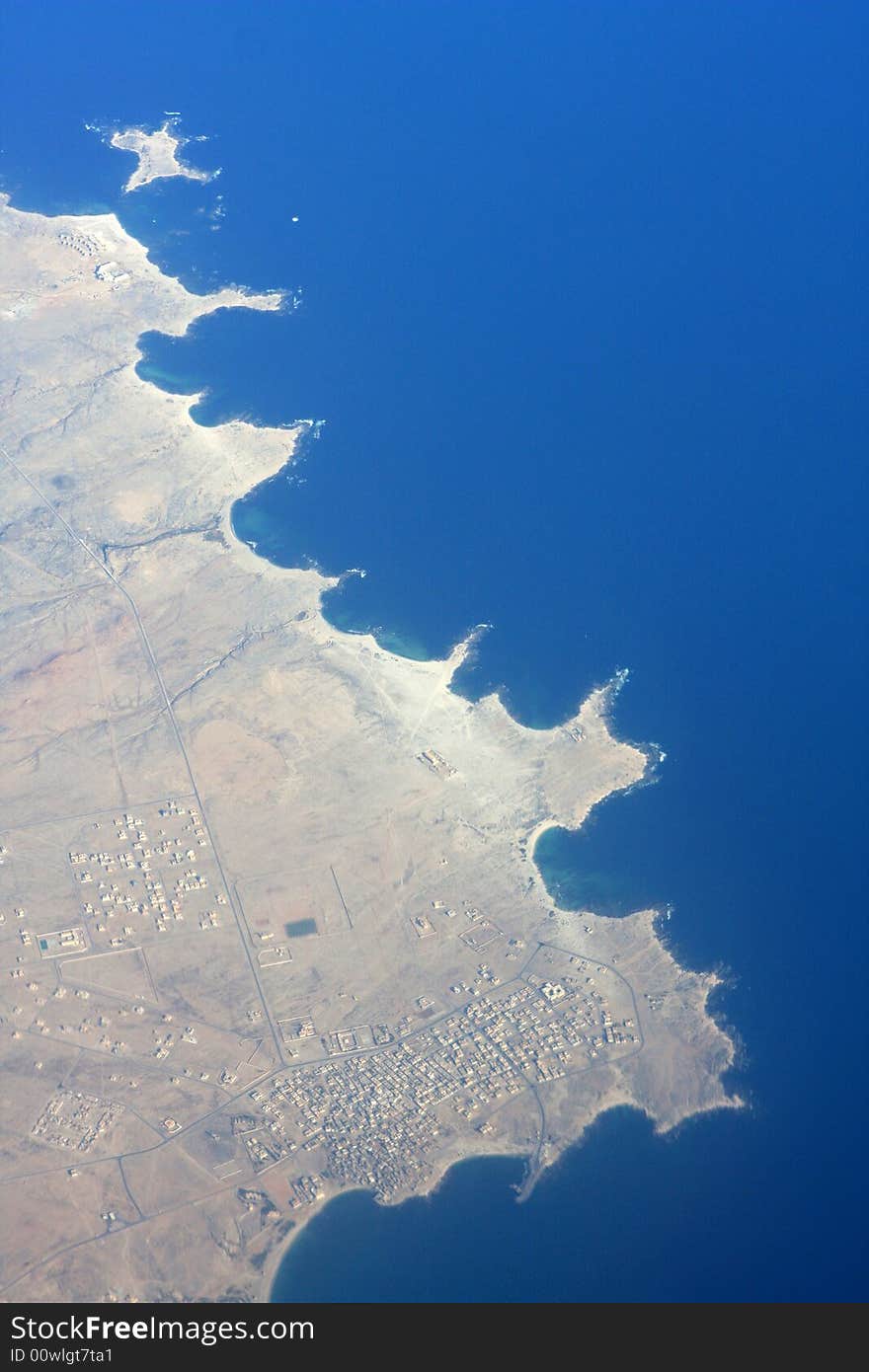 A view of land and ocean from the sky. A view of land and ocean from the sky