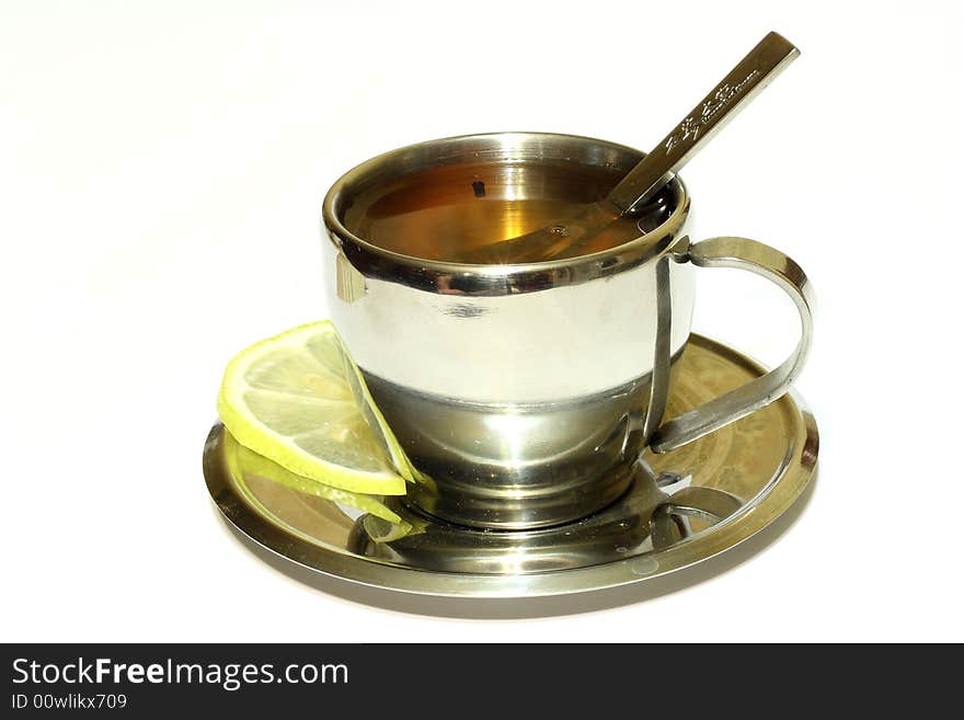 Metallic cup of tea with lemon on white background isolated