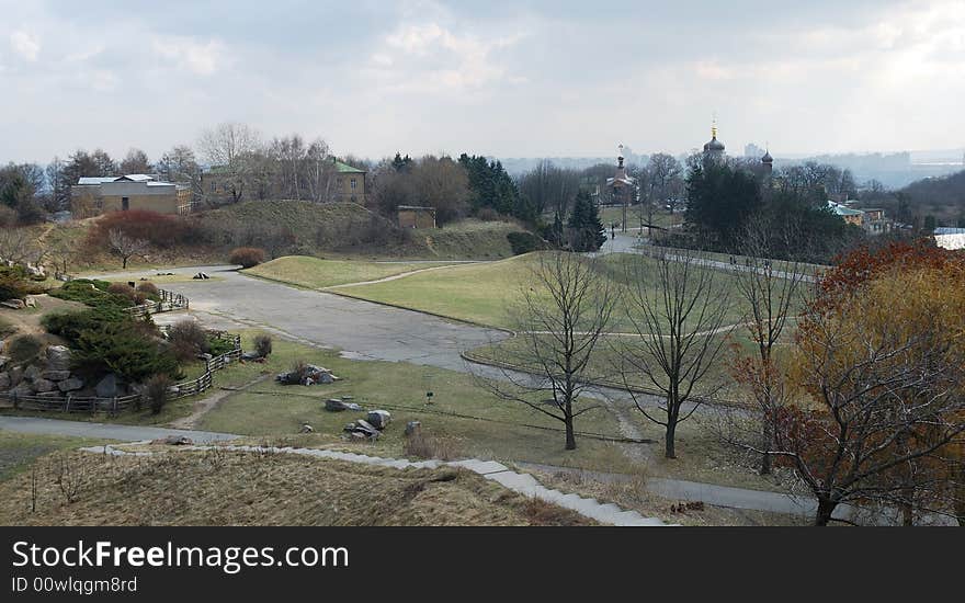 Early spring view down city garden with green lawns, stone hills and curve pathes. Early spring view down city garden with green lawns, stone hills and curve pathes