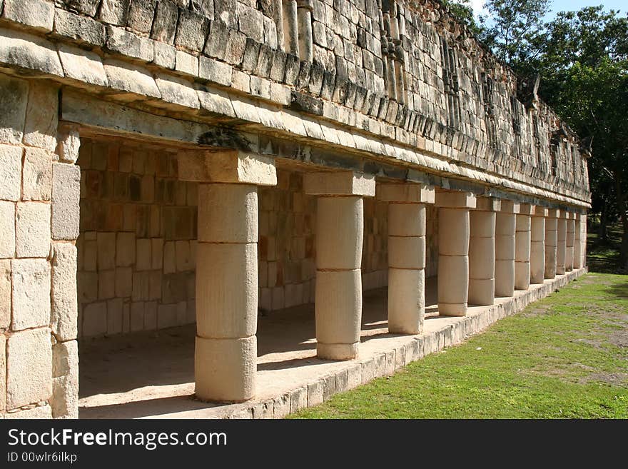 Row of antique maya columns with green grass. Row of antique maya columns with green grass