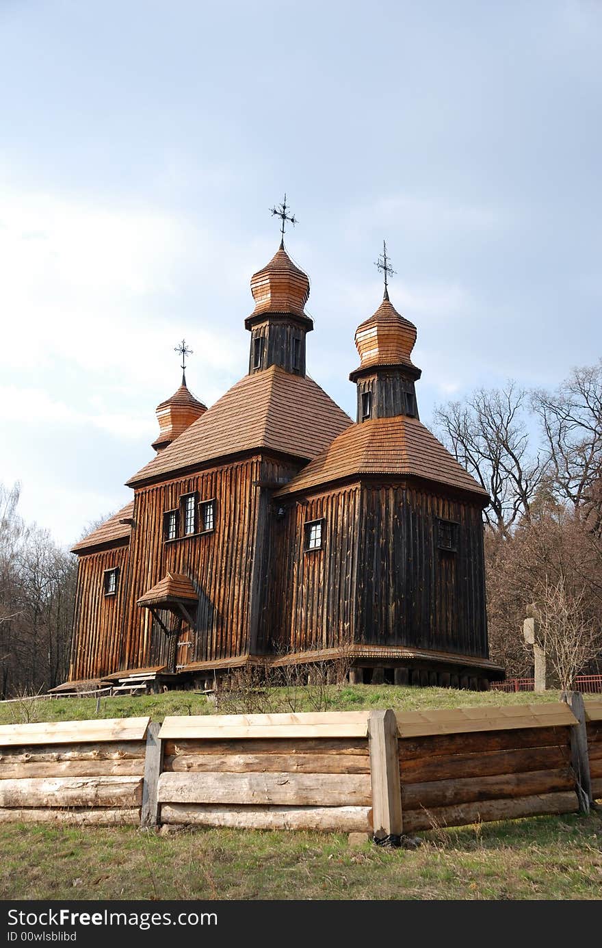 Wooden Orthodox church in bare spring park, old dark timber walls, domes, roofs weathered, Pirogovo, Kiev, Ukraine. Wooden Orthodox church in bare spring park, old dark timber walls, domes, roofs weathered, Pirogovo, Kiev, Ukraine