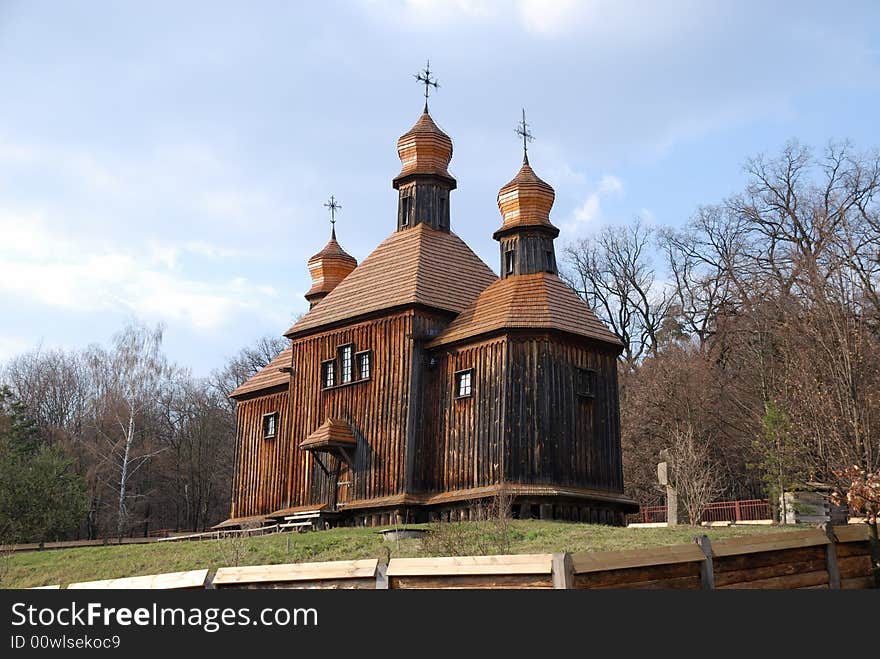 Wooden Orthodox church in bare spring park, old dark timber walls, domes, roofs weathered, Pirogovo, Kiev, Ukraine. Wooden Orthodox church in bare spring park, old dark timber walls, domes, roofs weathered, Pirogovo, Kiev, Ukraine