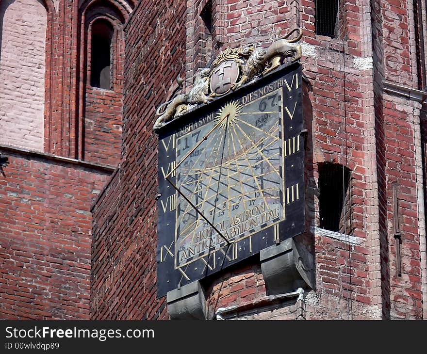 The historical sundial detail. Red brick tower in Gdańsk, Poland. The historical sundial detail. Red brick tower in Gdańsk, Poland.