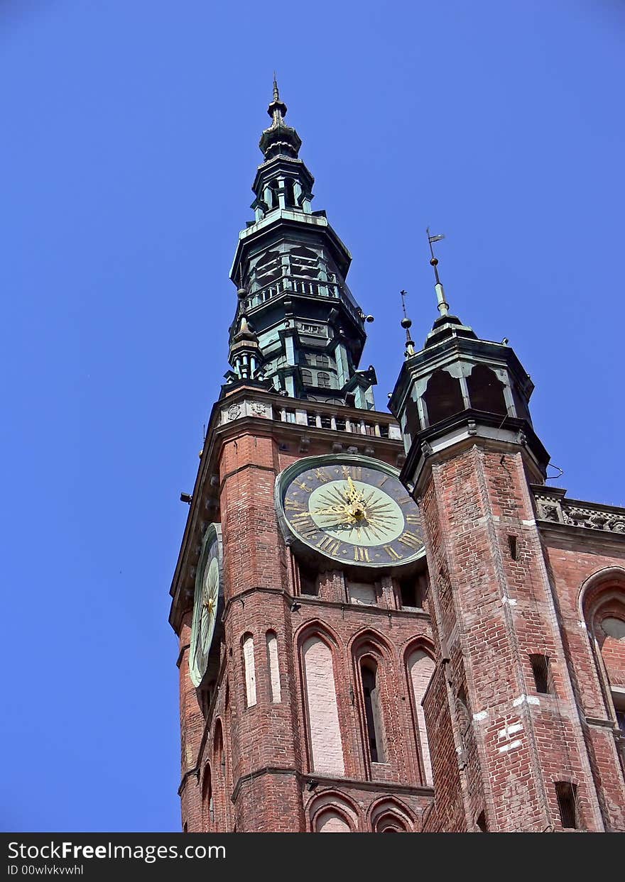 The historical building in Gdańsk, Poland. Bricked tower with big clock. The historical building in Gdańsk, Poland. Bricked tower with big clock.