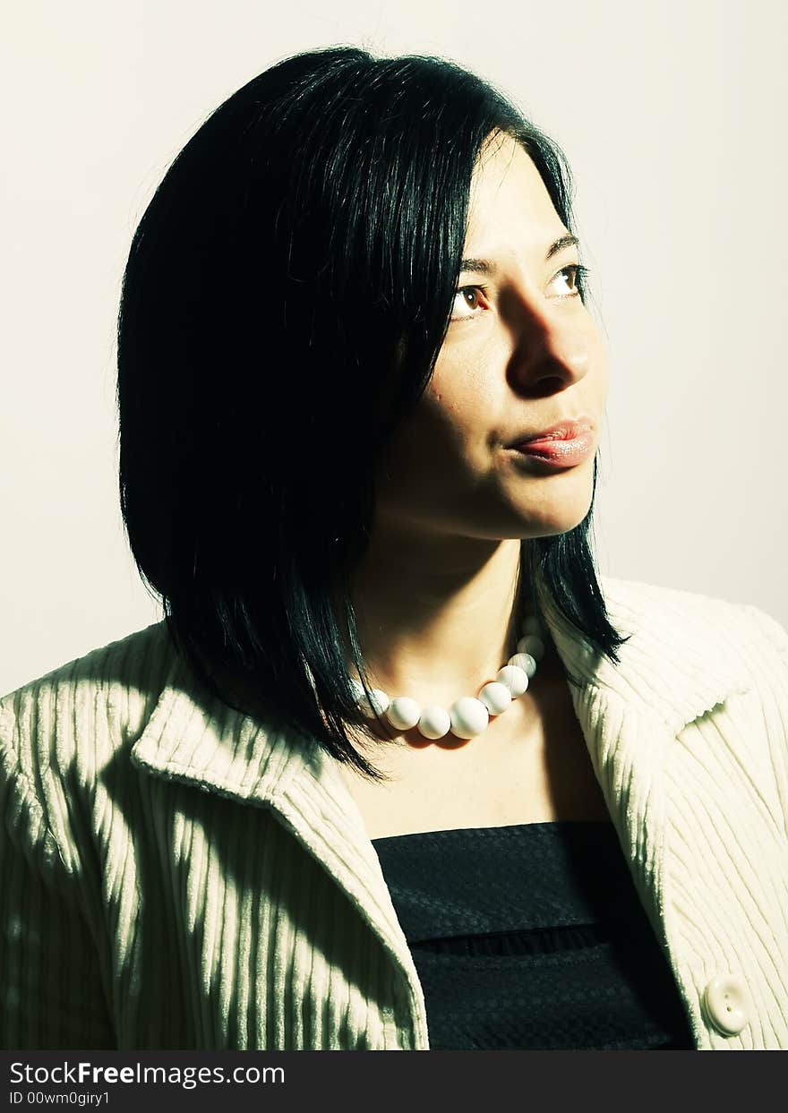 A high-key portrait about a young attractive lady with black hair who is looking up and she is dreaming. She is wearing a white coat, a black dress and a white necklace. A high-key portrait about a young attractive lady with black hair who is looking up and she is dreaming. She is wearing a white coat, a black dress and a white necklace.