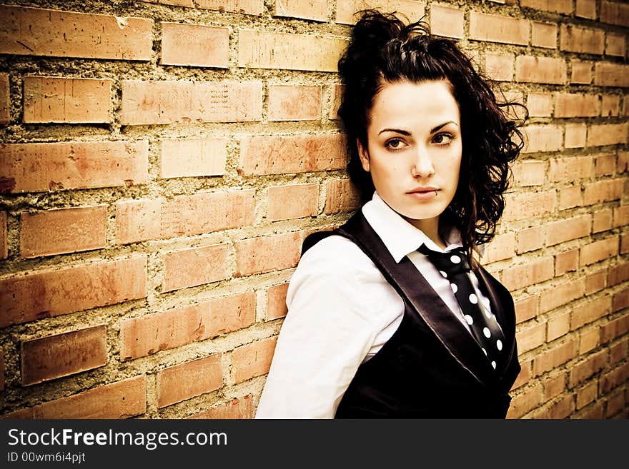 Young curly girl on wall as background