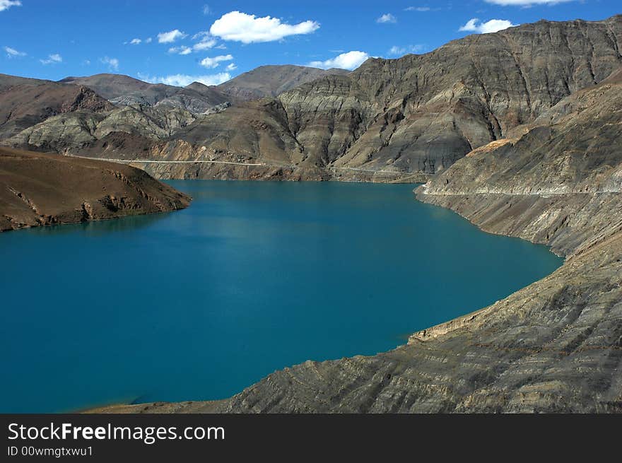 A blue plateau lake surrounded with rocky mountains.The Sheep Lake, a saint lake in Tibet,China. A blue plateau lake surrounded with rocky mountains.The Sheep Lake, a saint lake in Tibet,China.