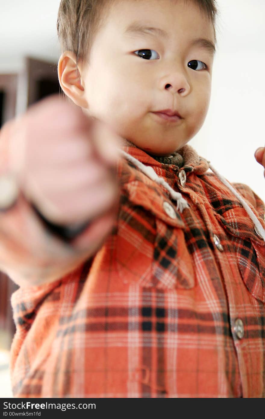 A asian boy make a cockeyed   and looking at his finger. A asian boy make a cockeyed   and looking at his finger