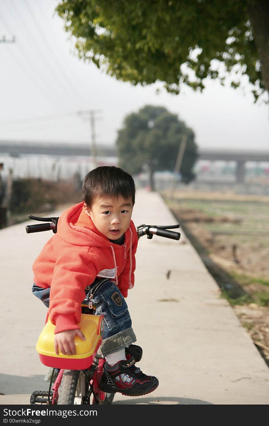 A Asian boy on his bike on road