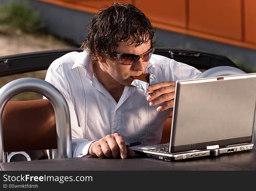 Man using a laptop outdoors. Man using a laptop outdoors