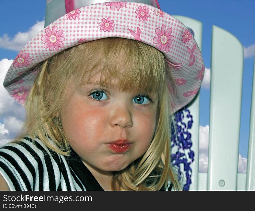 Little girl wearing her new summer hat. Little girl wearing her new summer hat.