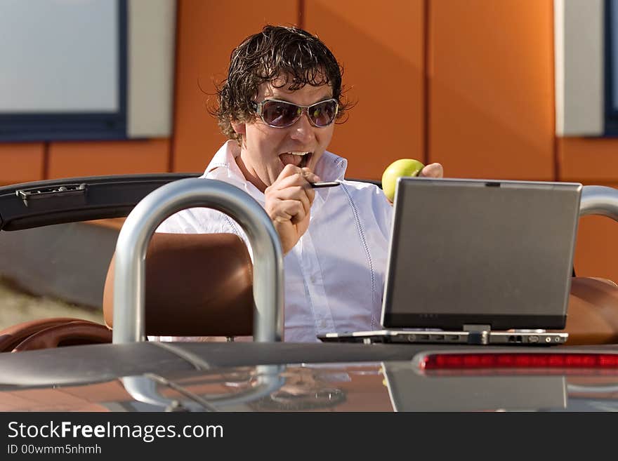 Man using a laptop outdoors. Man using a laptop outdoors