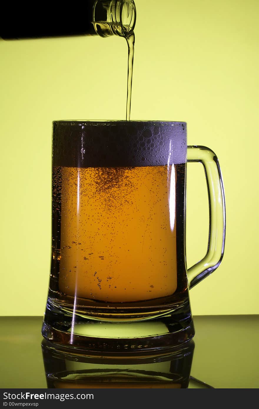 Beer in a glass. Yellow light backgrounds. Beer in a glass. Yellow light backgrounds.