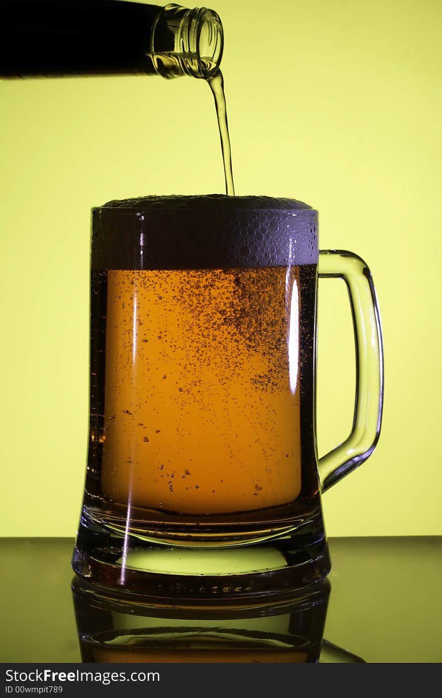 Beer in a glass. Yellow light backgrounds. Beer in a glass. Yellow light backgrounds.