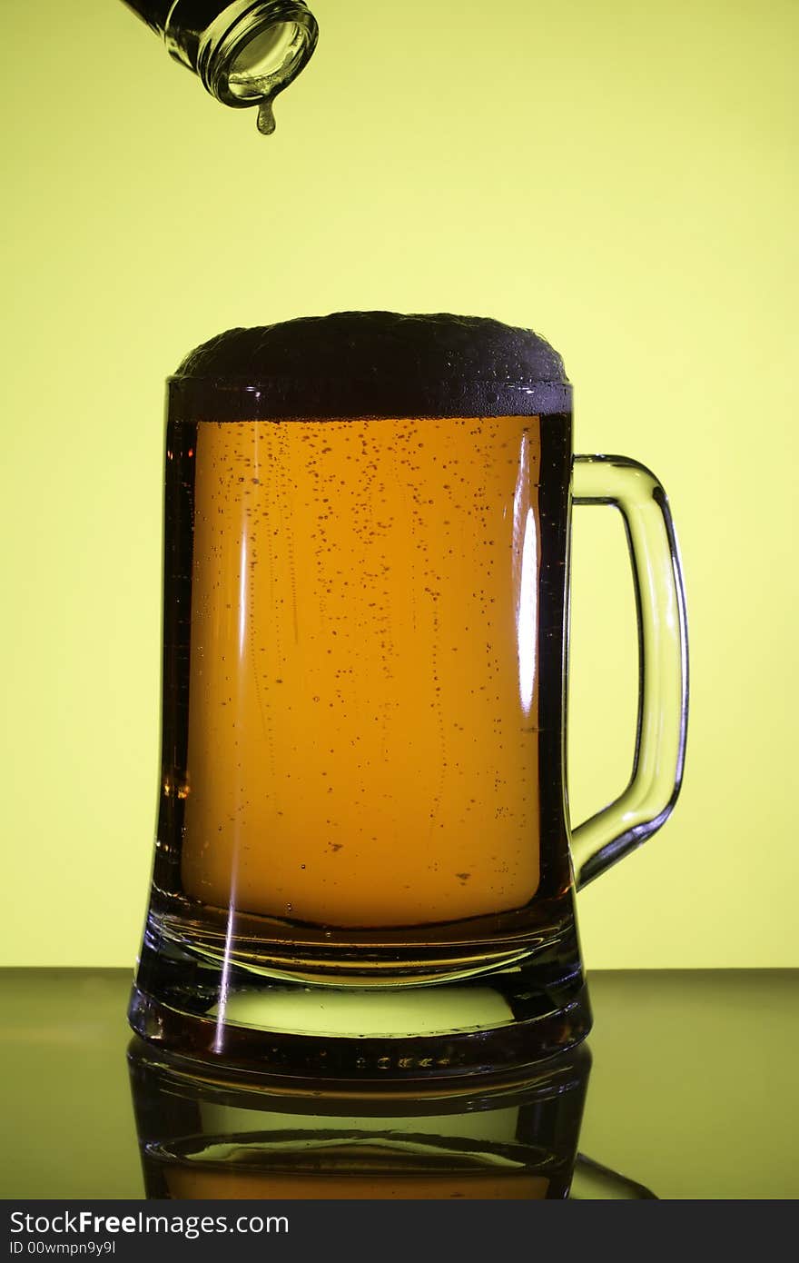 Beer in a glass. Yellow light backgrounds. Beer in a glass. Yellow light backgrounds.