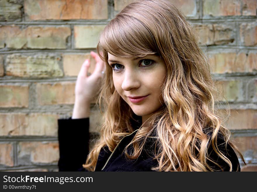 Beautiful blond woman on brick wall