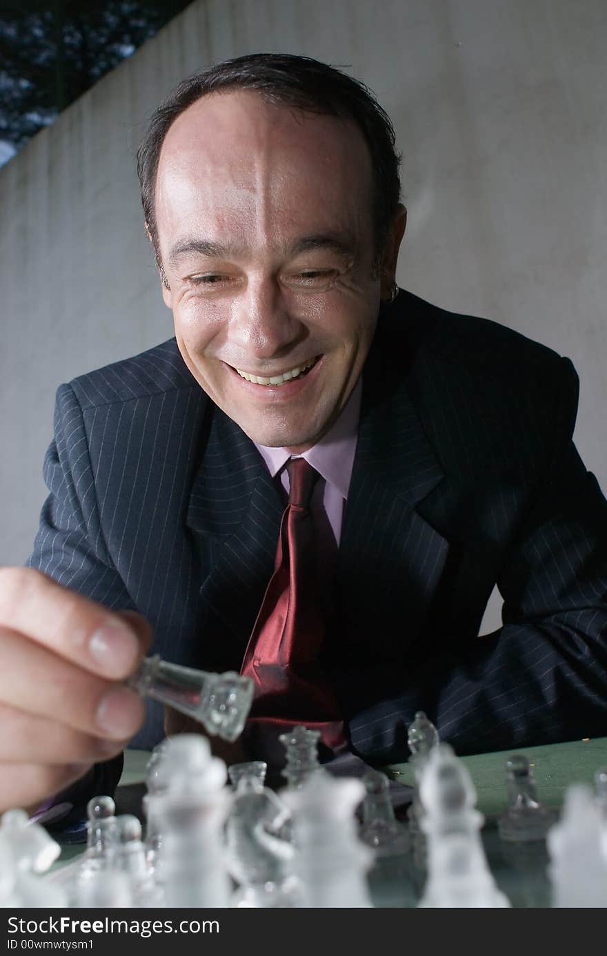 A close-up shot of a businessman playing with chess pieces.