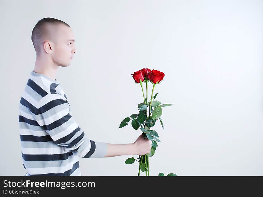Young man with red roses at white background. Young man with red roses at white background