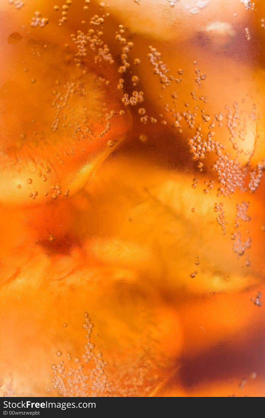 Cold fizzy cola with ice in a glass. Close up. Abstract background.