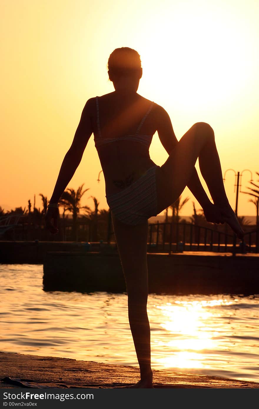 Yoga at sunset near the ocean.