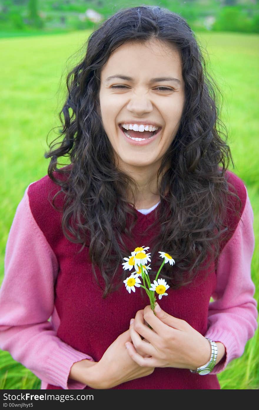 Happy young woman in green field of wheat, holding flowers. Happy young woman in green field of wheat, holding flowers