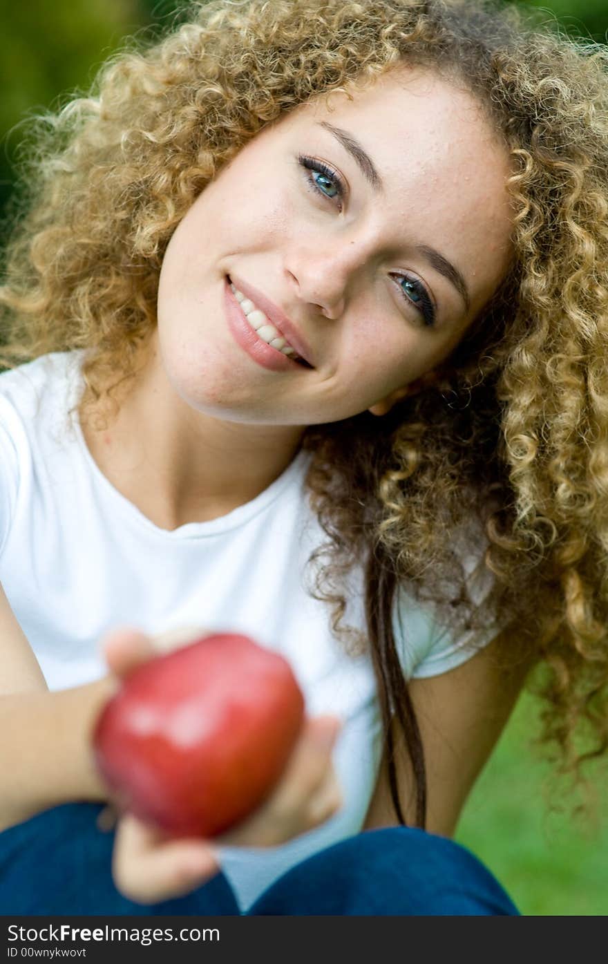 A young attractive woman holding an apple