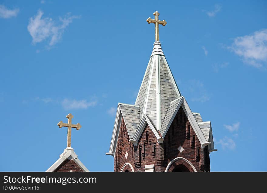 Two Church Steeples Against a Blue Cloudy Sky