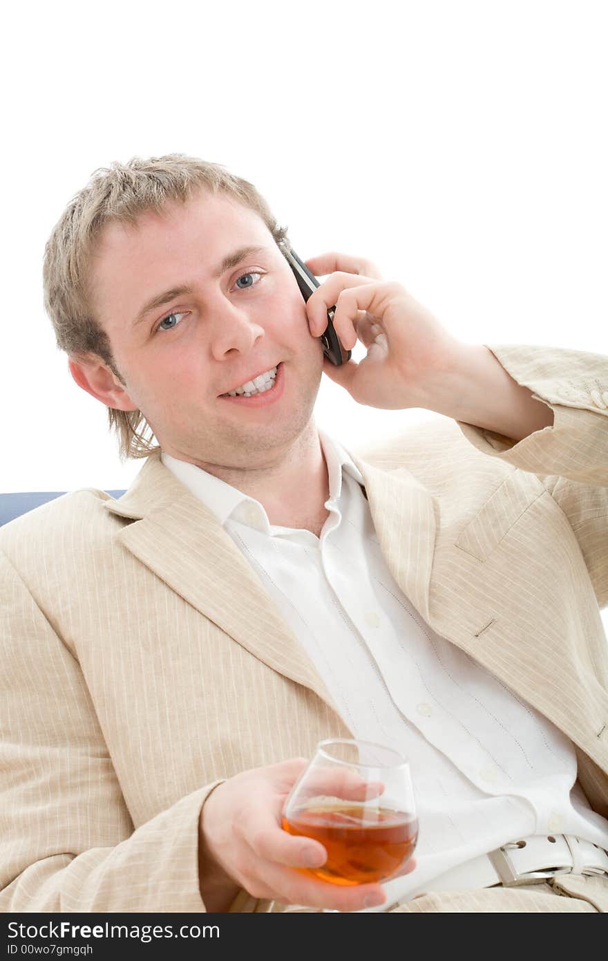 Successful smiling businessman with glass of cognac call by cellular phone. Isolated on white. Successful smiling businessman with glass of cognac call by cellular phone. Isolated on white