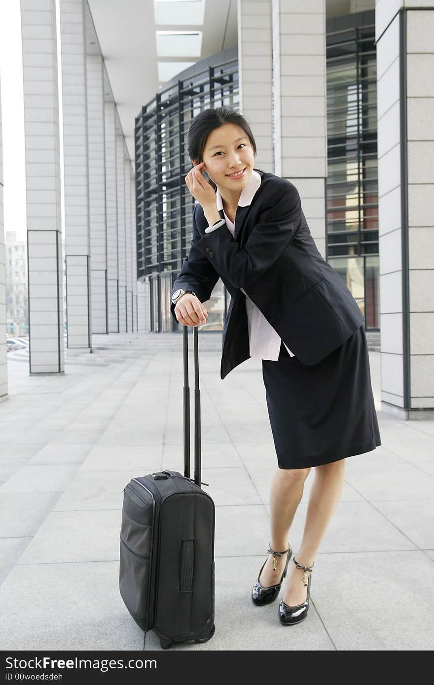 Young chinese business women with suitcase