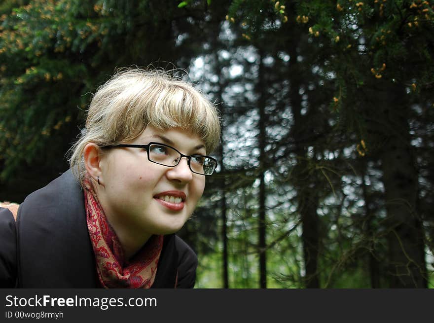 Caucasian girl in the coniferous forest. Close-ups portrait. Forest is out of focus. Caucasian girl in the coniferous forest. Close-ups portrait. Forest is out of focus