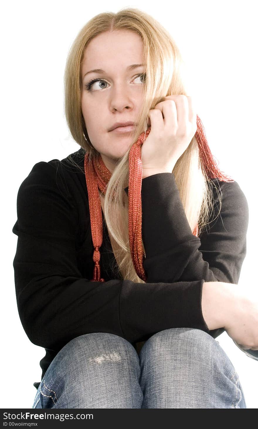 Pretty blonde in black coat, blue jeans and red scarf on white