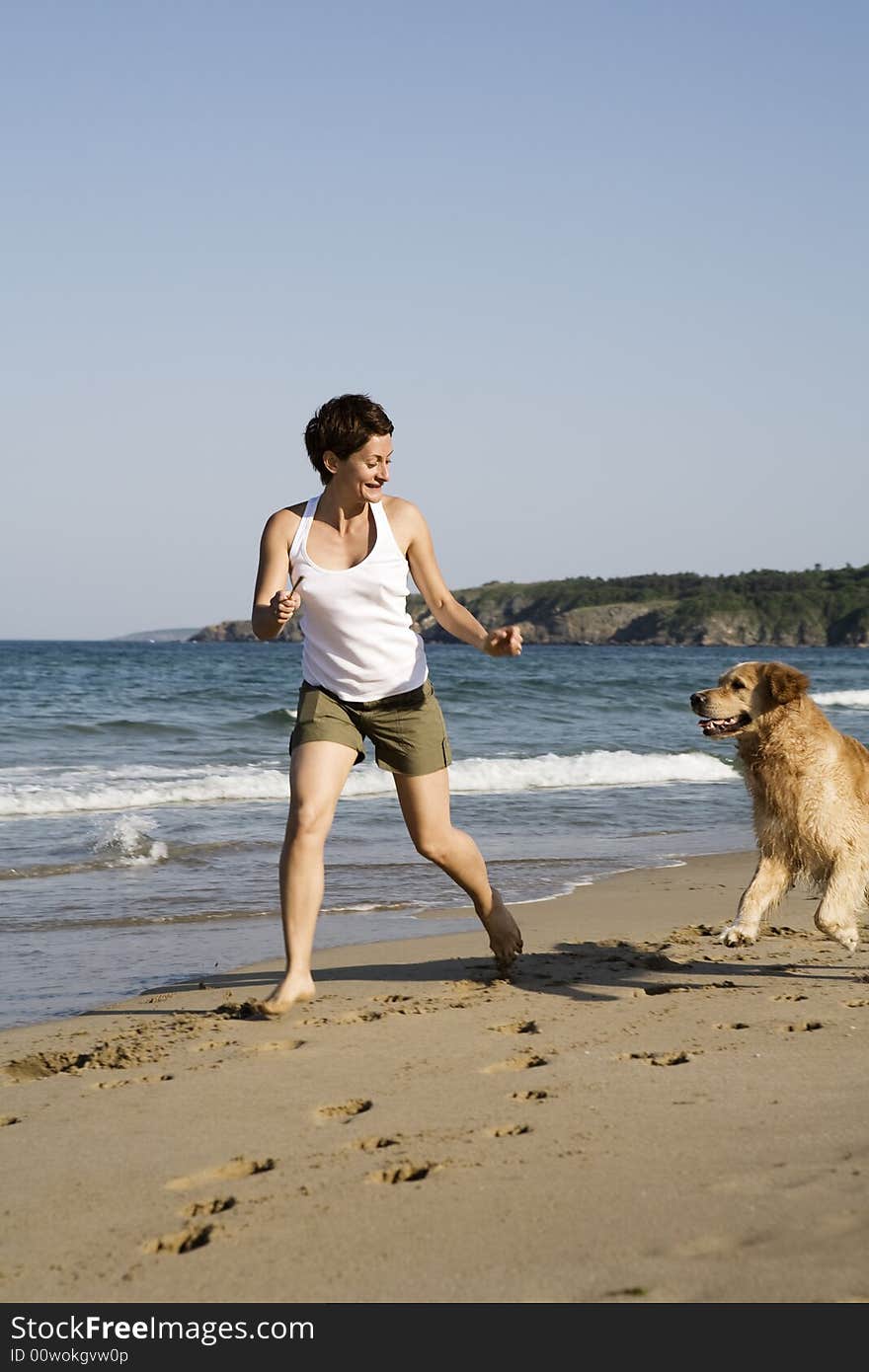 Young girl and dog playing on the beach