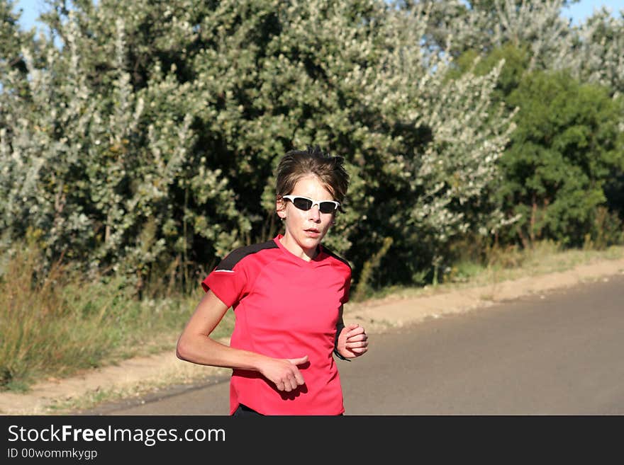 Female athlete in red running for training.