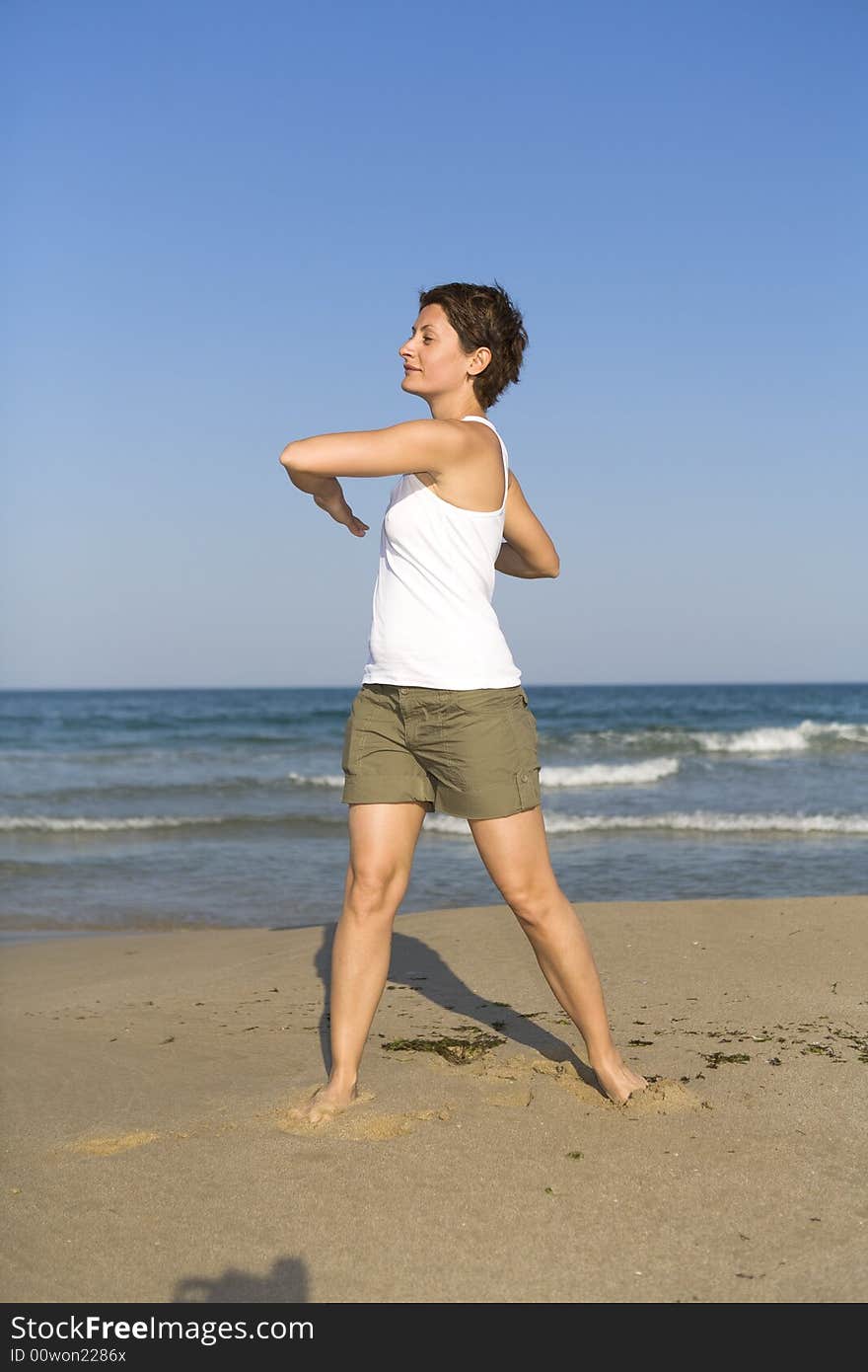 Young girl exercises gymnastics on the beach