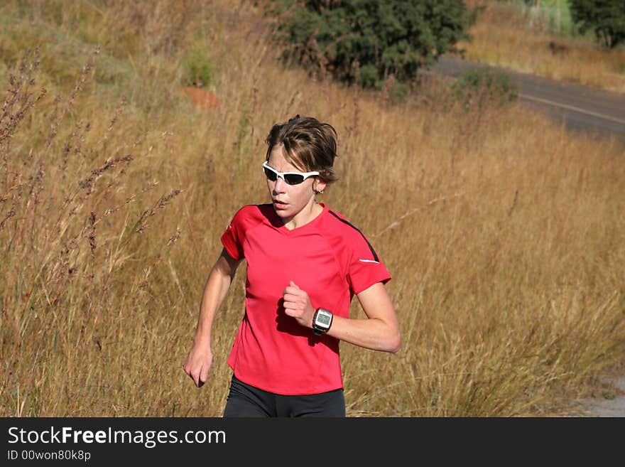 Female athlete in red running for training.