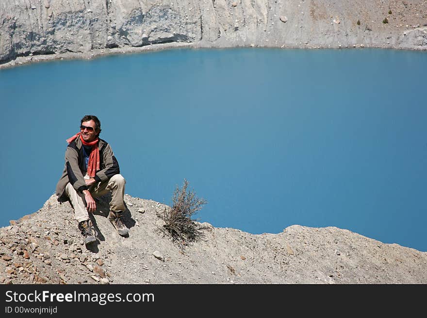 Trekker sitting on mountain summit