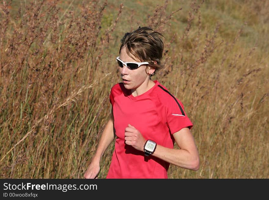 Female athlete in red running for training.