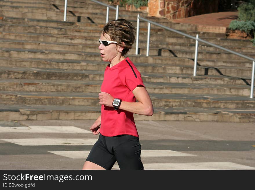 Female athlete in red running for training.