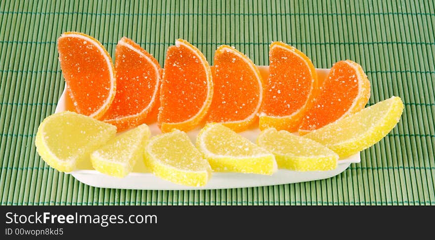 Fruit jellies lemon and orange lobules on a saucer