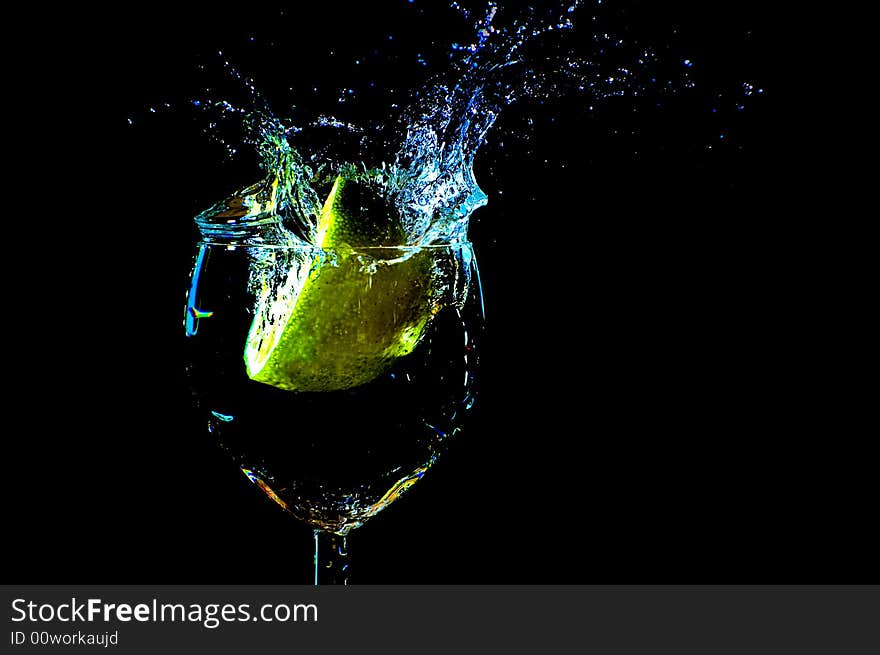 A peace of lemon falling in a glas with water. A peace of lemon falling in a glas with water