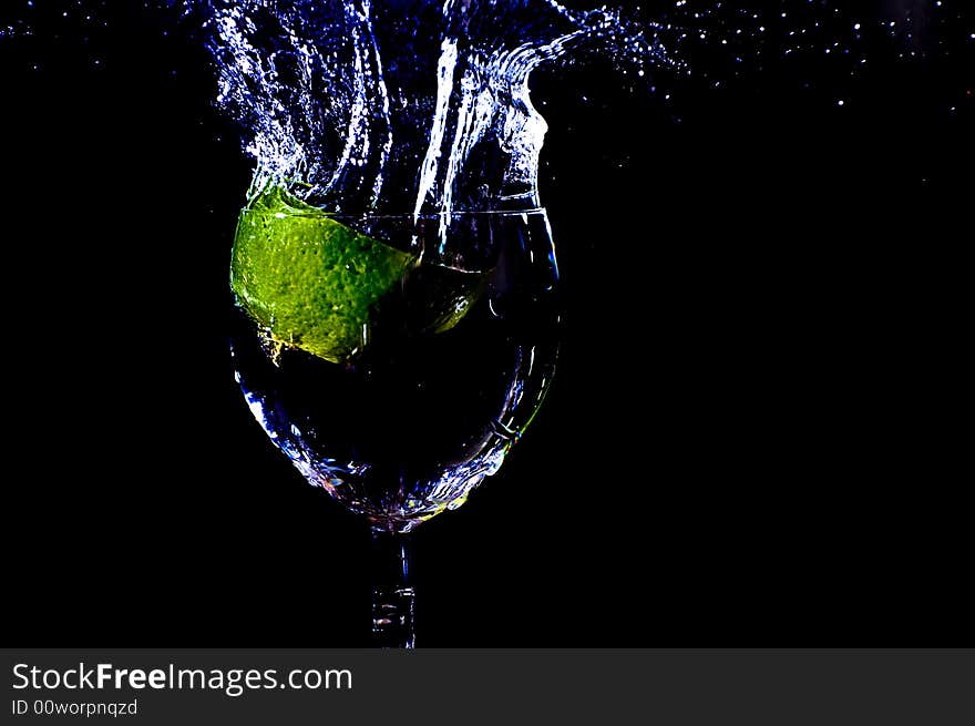 A peace of lemon falling in a glas with water. A peace of lemon falling in a glas with water