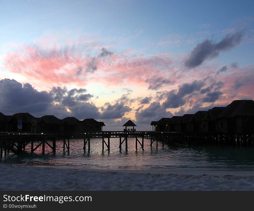 In this sunset you can see pink and dark clouds around maldivian overwaters. In this sunset you can see pink and dark clouds around maldivian overwaters