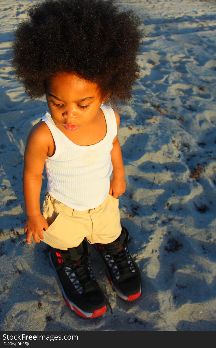 Little toddler wearing really big shoes. Little toddler wearing really big shoes.