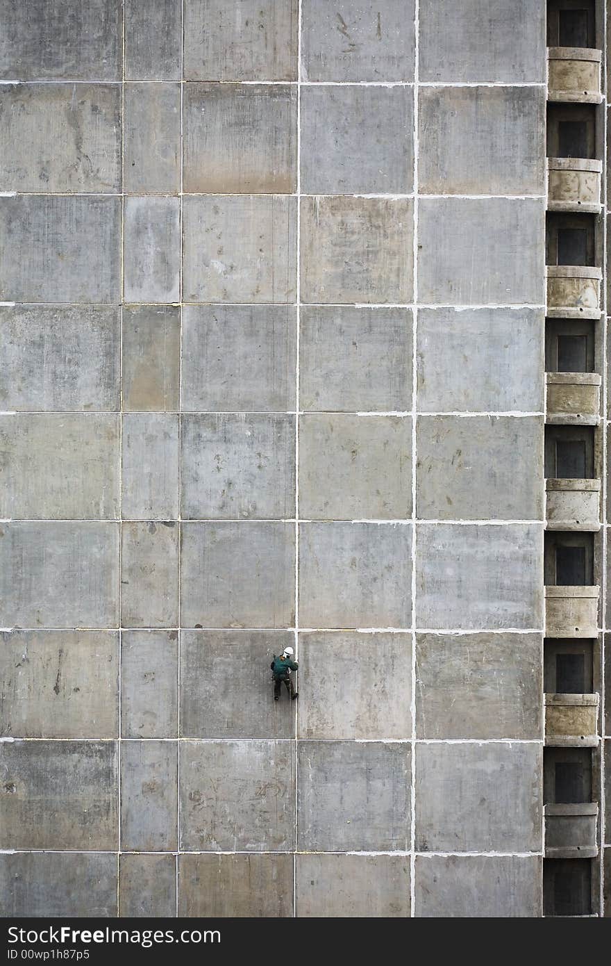 The steeplejack on a concrete wall of a under construction house