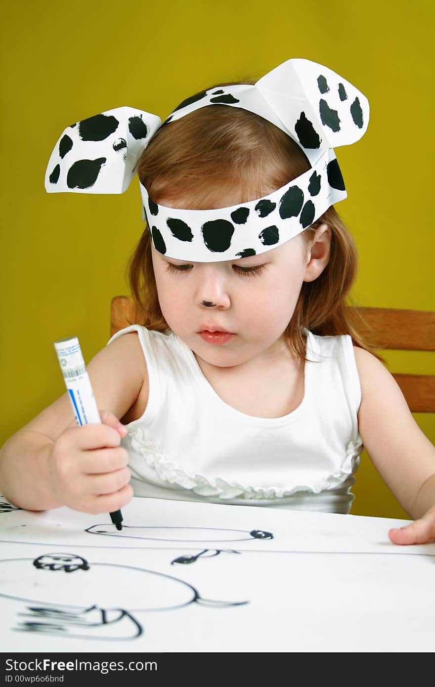 The small girl with dalmatian mask sketches the dog