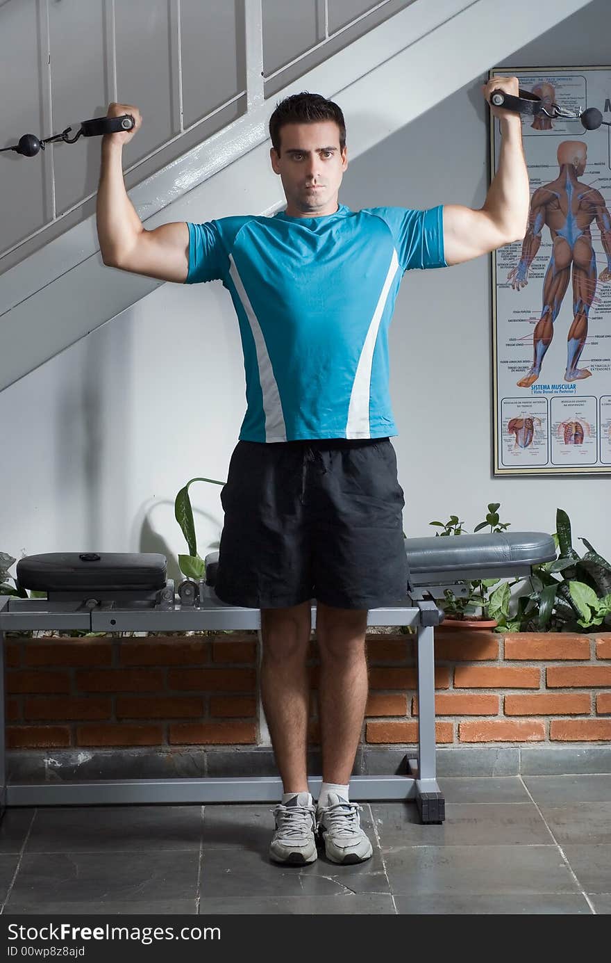 A shot of male weightlifter standing up doing curls.