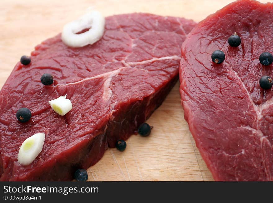 Two fresh and raw beef steaks with spices. Two fresh and raw beef steaks with spices