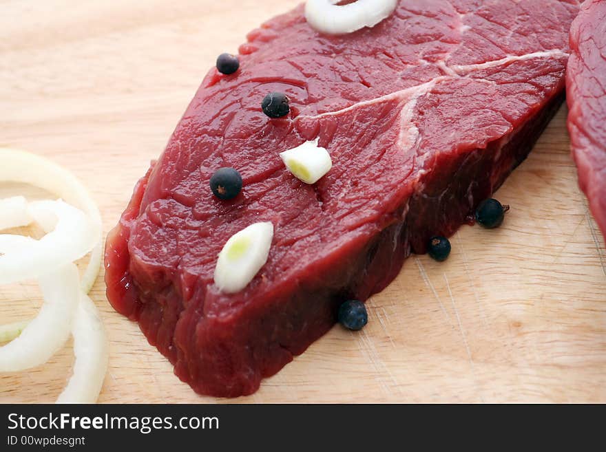 Two fresh and raw beef steaks with spices. Two fresh and raw beef steaks with spices