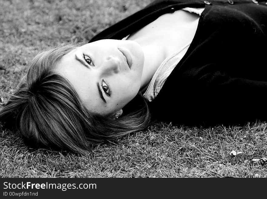 Laying woman staring at camera, black and white.